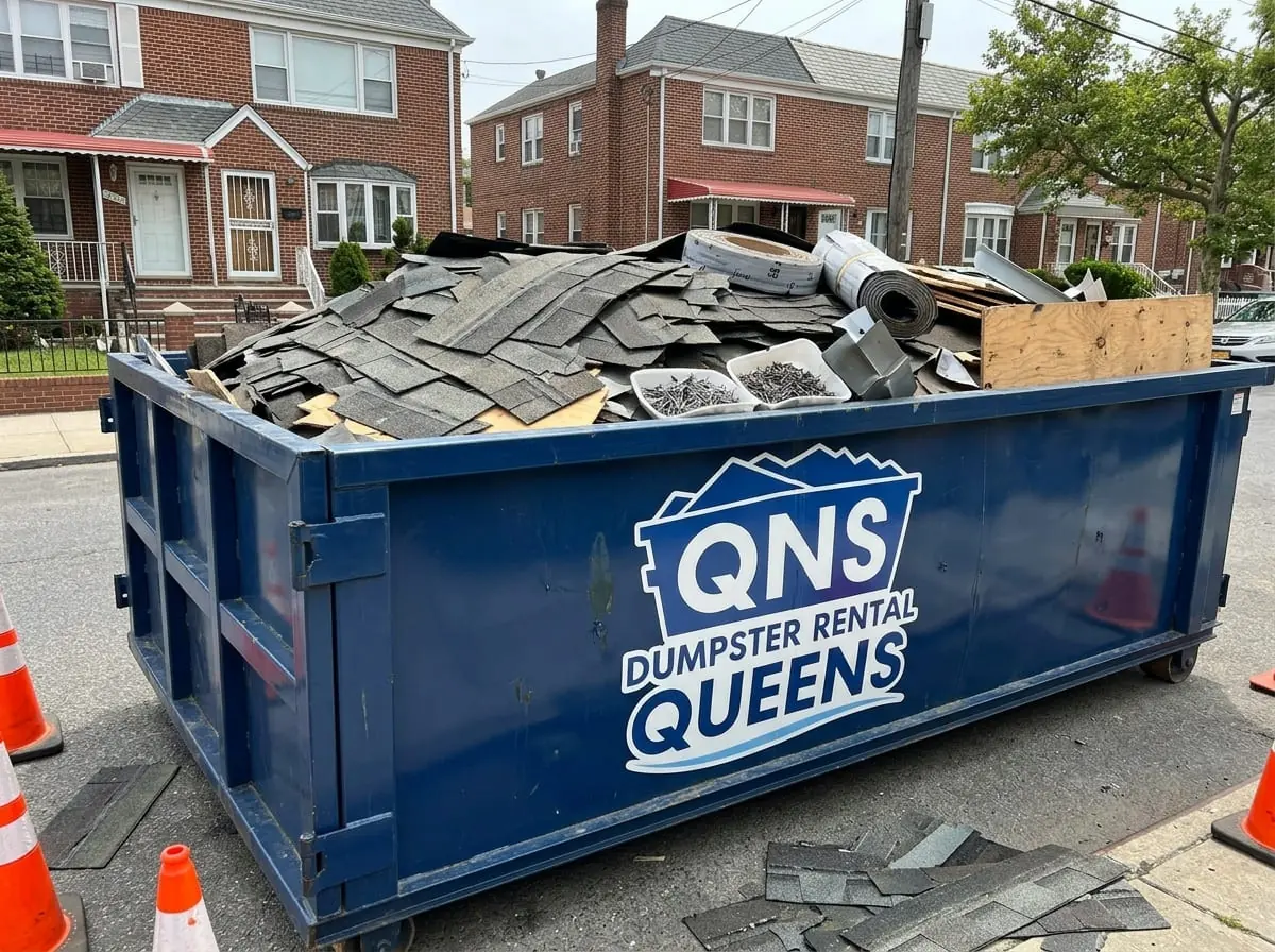 Roofing and heavy debris dumpster rental Dumpster loaded with roofing tear-off debris near Long Island City, NY
